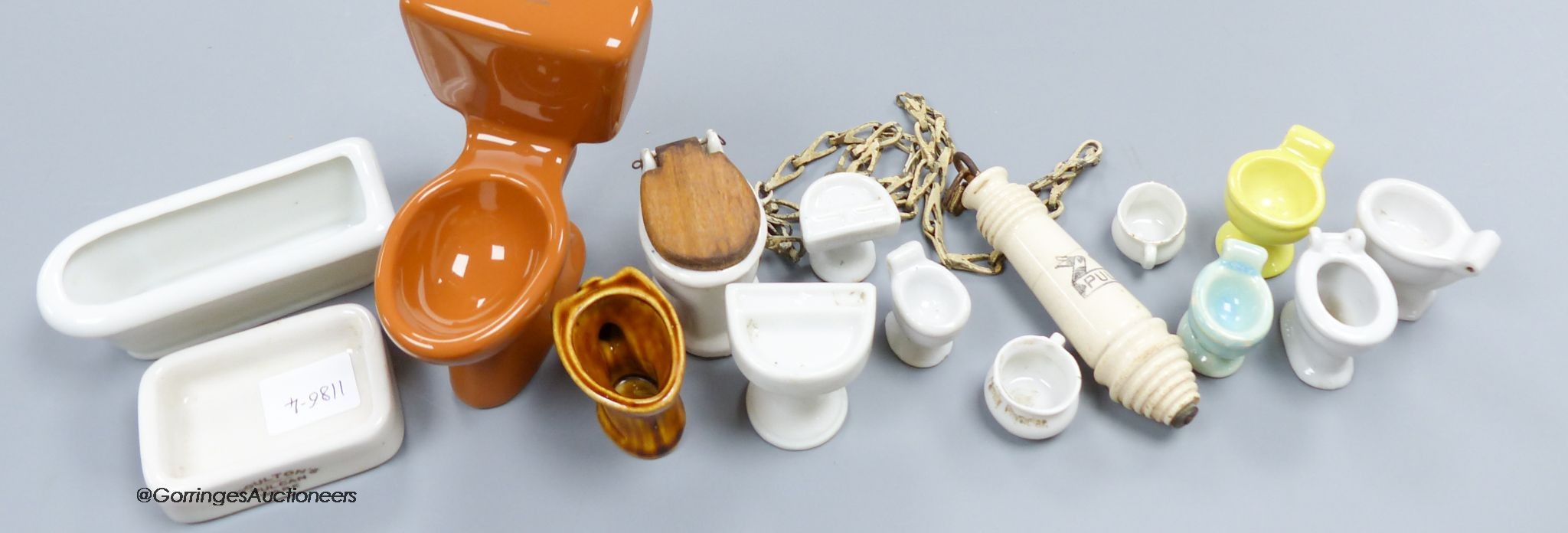 A group of various miniature models of toilets and a pull chain